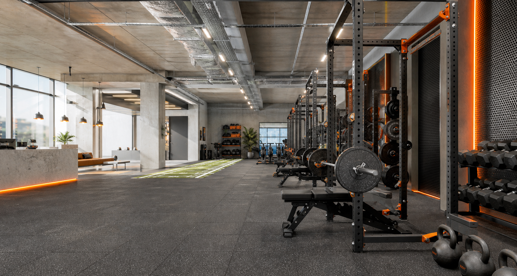 Industrial strength gym with racks, weights, concrete and warm orange lighting